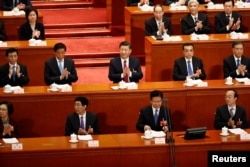Chinese President Xi Jinping, Chinese Premier Li Keqiang and other officials applaud at the second plenary session of the National People's Congress (NPC) at the Great Hall of the People in Beijing, China, March 9, 2018.
