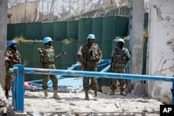 United Nations soldiers stand in front of the destroyed gate outside the UN's office in Mogadishu, Somalia on July, 26, 2016.