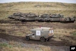 An Israeli military ambulance drives past tanks in the Israeli-controlled Golan Heights, near the border with Syria, May 10, 2018.