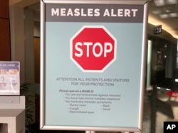 Signs posted at a clinic in Vancouver, Washington warns patients and visitors of a measles outbreak. A measles outbreak near Portland, Ore., has revived a bitter debate over personal belief exemptions to childhood vaccinations, 2019. (File Photo)