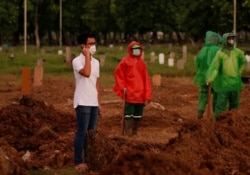 Firos Justin Sumantri, putra dr. Ratih Purwarini yang meninggal setelah tertular virus corona, berdoa di makam ibunya, di Jakarta, 31 Maret 2020. (Foto: Reuters)