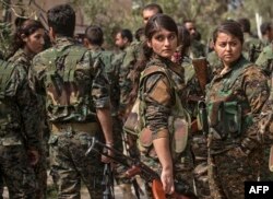 Borci Sirijskih demokratskih snaga (SDF), koje podržava Amerika, uključujući i žene, okupljaju se na proslavi u blizini naftnog polja u Omaru u istočnoj sirijskoj pokrajini Deir Ezor, 23. marta 2019, nakon proglašenja totalne eliminacije samoproklamovanog kalifata Islamske države.