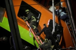 Rescuers work at a site where an overpass for a metro partially collapsed with train cars on it at Olivos station in Mexico City, Mexico May 3, 2021. REUTERS/Luis Cortes