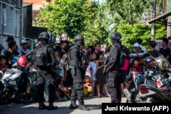 Anggota polisi anti-terorisme Densus 88 mengepung sebuah jalan ketika mereka menggeledah sebuah rumah di Surabaya, Jawa Timur, pada 19 Juni 2017, menyusul penangkapan seorang pria yang diduga terkait dengan ISIS. (Foto: AFP)
