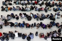 FILE - Cambodian fishermen rescued from Thai fishing boats have breakfast at a building in the Chroy Changva district of Phnom Penh, June 18, 2015.