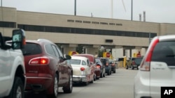 FILE - In this July 20, 2018 photo, traffic backs up at the border station as motorists leave Manitoba, Canada, for the United States at Pembina, N.D. 