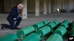 Ambasador Sjedinjenih Američkih Država u Bosni i Hercegovini Michael J. Murphy kleči pored tabuta u kojima se nalaze posmrtni ostaci 30 novoidentifikovanih žrtava genocida u Srebrenici u Potočarima, Bosna, ponedjeljak, 10. jula 2023.