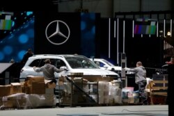 Cars and workers are pictured at the Palexpo exhibition center as the 90th edition of the International Motor Show is cancelled to curb the spread of the coronavirus, in Geneva, Switzerland, Feb. 28, 2020.