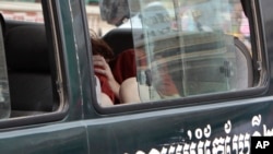 Tammy Davis-Charles, charged with providing commercial surrogacy services, hides her face as she is transported to the Phnom Penh Municipal Court in Phnom Penh, Cambodia, June 13, 2017.