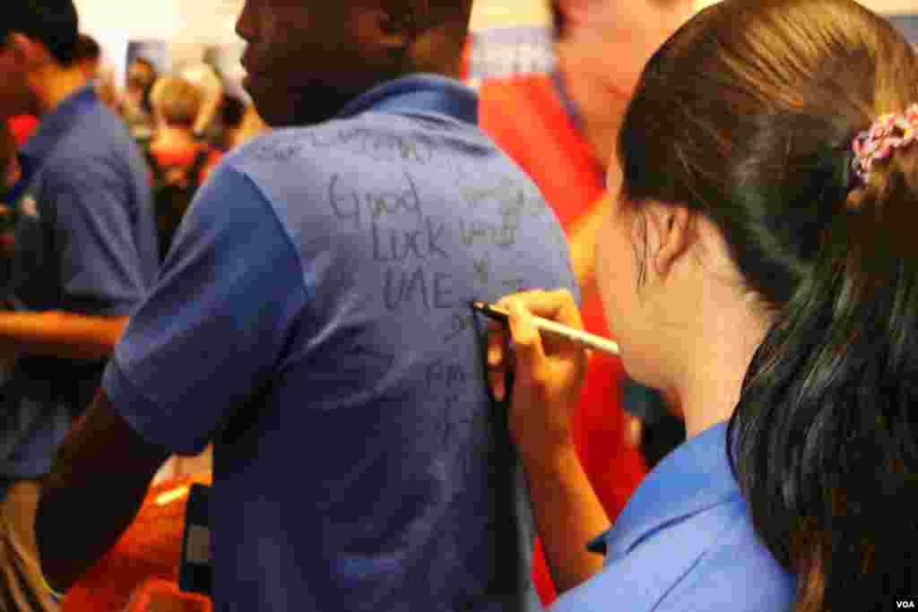 Another member of the Cambodian robotics team signs on another country's team member's shirt after the closing of the First Global Challenge robotics competition in Washington, DC, Tuesday, July 18, 2017. (Nem Sopheakpanha/VOA Khmer)