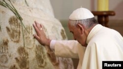 Paus Fransiskus berdoa di depan patung Perawan Maria di gereja Caacupe di Caacupe, Paraguay (11/7). (Reuters/Alessandro Bianchi)