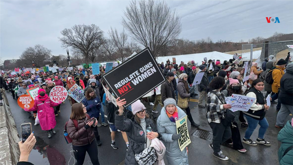 Los manifestantes llevaban carteles que decían "Regular las armas, no a las mujeres" y "Detengan el racismo ahora".