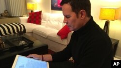 Juan Carlos Cruz reads from his tablet during an interview with the Associated Press in Philadelphia, Pennsylvania, February 4, 2017.