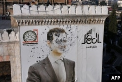 This aerial picture shows a bullet-riddled portrait of Syrian President Bashar al-Assad adorning Hama's municipality building after it was defaced following the capture of the city by anti government fighters, Dec. 6, 2024.