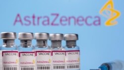 Vials labelled "Astra Zeneca COVID-19 Coronavirus Vaccine" and a syringe are seen in front of a displayed AstraZeneca logo, in this illustration photo taken March 14, 2021.