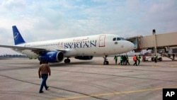 This photo released by the Syrian official news agency SANA, shows a Syrian commercial plane carrying Syrian officials and journalists after it landed at Aleppo airport, Syria, Wednesday, Feb. 19, 2020. 