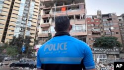 A Lebanese police officer looks at damaged apartments that were hit by Israeli strike early Sept. 30, 2024. 