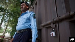 មន្រ្តី​ប៉ូលិស​ប៉ាគីស្ថាន​ម្នាក់​ឈរ​នៅ​ខាង​ក្រៅ​ការិយាល័យ​របស់​អង្គការ Save the Children ដែល​ត្រូវ​បាន​គេ​បិទ​នៅ​ក្នុង​ក្រុង​អ៊ីស្លាម៉ាបាដ ប្រទេស​ប៉ាគីស្ថាន​ កាលពី​ថ្ងៃទី១២ ខែមិថុនា ឆ្នាំ២០១៥។