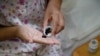 FILE - A woman suffering from cervical cancer takes her medicine at a treatment facility in Beijing, China, June 23, 2016.
