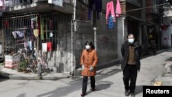 Algunos ciudadanos, pertrechados con mascarillas sanitarias, se aventuraban a deambular por las desérticas calles de Wuhan el 4 de marzo de 2020.