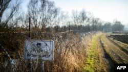 A placard saying "Attention! State border" is displayed on a barbed wire fence at the Slovenian-Croatian border close to the village of Rigonce, in Slovenia on Feb. 16, 2017.