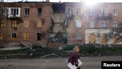 Žena prolazi pored zgrade pogođene u raketnom napadu, dok se nastavlja ruska invazija na Ukrajinu u Bahmutu u Donbasu, 1. novembra 2022. 
