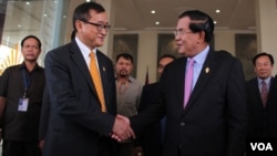 រូបឯកសារ៖ លោក​នាយក​រដ្ឋ​មន្រ្តី​ហ៊ុន​ សែន​ និង​លោក​សម​ រង្សី​ ប្រធាន​គណបក្ស​សង្គ្រោះ​ជាតិ​ ចាប់​ដៃ​គ្នា​នៅ​មុខ​​រដ្ឋសភាជាតិ​ បន្ទាប់​ពី​ការ​បោះឆ្នោត​ផ្តល់​សេចក្តី​ទុក​ចិត្ត​គណៈកម្មាធិការ​ជាតិ​រៀបចំ​ការបោះឆ្នោត ​ភ្នំពេញ​ ថ្ងៃ​ទី​៩​ ខែ​មេសា​ ឆ្នាំ​២០១៥។​​ (នូវ​ ពៅ​លក្ខិណា/VOA)