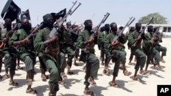 FILE - Hundreds of newly trained al-Shabab fighters perform military exercises in the Lafofe area some 18 km south of Mogadishu, in Somalia. 