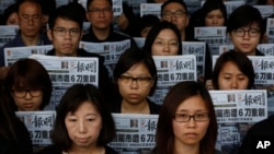 Nhân viên của tờ Minh Báo cùng cầm tờ báo có trang nhất đăng bài viết về vụ tấn công ông Lưu Tiến Đồ, cựu chủ biên tờ báo này