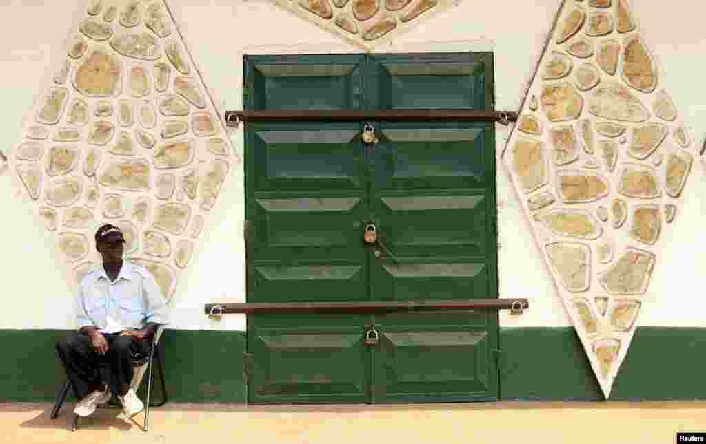 A security guard sits near a closed shop in Bangui, Central African Republic, December 31, 2012.