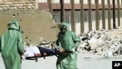 FILE - People in protective suits and gas masks conducting a drill on how to treat casualties of a chemical weapons attack in Aleppo, Syria.