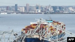 Daraja la la Francis Scott Key likiwa limeporomoka, baada ya kugongwa nguzo na meli ya makontena ya Dali, ikipelekea magari mengi na watu kutumbukia kwenye mto.Kamishna wa Polisi wa Baltimore Richard Worley alisema hakuna dalili za ugaidi. Baltimore, Maryland, Machi 26, 2024.