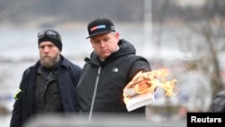 راسموس پالودان، سیاستمدار راست افراطی دنمارکی-سویدنی هنگام آتش زدن قران در مقابل سفارت ترکیه واقع در استکهلم، پایتخت سویدن