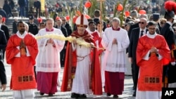 Pope Francis holds a palm frond as he celebrates a Palm Sunday Mass in St. Peter's Square at the Vatican, March 25, 2018.