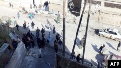 A handout picture released by the Syrian Arab News Agency shows Syrians inspecting the site of a car bomb blast in the northwestern city of Idlib, January 16, 2013.