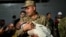 A soldier holds a baby as Turkish citizens evacuated from Lebanon disembark from the TCG Bayraktar war ship after its arrival at the southern Turkish port of Mersin on Oct. 10, 2024.