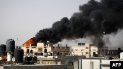 Густ, црн чад се издига од пожар во зграда предизвикана од израелско бомбардирање во Рафа во јужниот дел на појасот Газа, на 10 мај 2024 година, во услови на тековен конфликт меѓу Израел и палестинското движење Хамас (Фото: АФП)