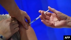 រូបឯកសារ៖ ស្ត្រីម្នាក់ ទទួល​ការចាក់​វ៉ាក់សាំង Pfizer-BioNTech ការពារ​ជំងឺ​កូវីដ១៩ នៅ​មណ្ឌល​សុខភាព​មួយ​នៅ​ទីក្រុង Cardiff កាលពី​ថ្ងៃទី៨ ខែធ្នូ ឆ្នាំ២០២០ នៅ​ពេល​ដែល​ចក្រភព​អង់គ្លេស ចាប់ផ្តើម​កម្មវិធី​ចាក់វ៉ាក់សាំង​ធំ​បំផុត​មិន​ធ្លាប់​មាន។