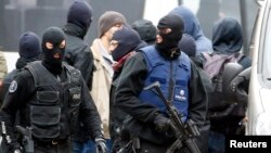 Belgian police stage a raid, in search of suspected muslim fundamentalists linked to the deadly attacks in Paris, in the Brussels suburb of Molenbeek, Nov. 16. 2015. 