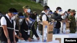 Miembros del Consejo Nacional Electoral de Ecuador preparan material para los comicios del 11 de abril de 2021.