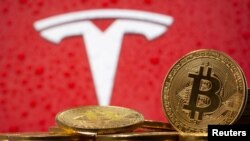 FILE PHOTO: Representations of virtual currency Bitcoin are seen in front of Tesla logo in this illustration taken, February 9, 2021. REUTERS/Dado Ruvic/File Photo
