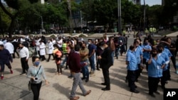 នយោជិត​នានា ចេញ​មក​ឈរ​នៅ​ខាងក្រៅ​អគារ​ធ្វើការ​របស់​ពួកគេ បន្ទាប់ពី​មាន​ការរញ្ជួយដី ដែល​មាន​កម្រិត​ដ៏​ខ្លាំង​មួយ នៅ​ទីក្រុងMexico Cityនៅ​ថ្ងៃអង្គារ​ទី២៣ ខែមិថុនា ឆ្នាំ ២០២០។ (AP)