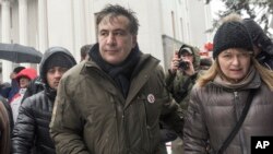 Former Georgian president Mikheil Saakashvili, left, and his wife Sandra Roelofs, right, attend a rally of his supporters as they camp out outside parliament demanding the resignation of the Ukrainian president, in Kiev, Ukraine, Dec. 6, 2017.