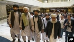 FILE - In this May 28, 2019 file photo, Mullah Abdul Ghani Baradar, the Taliban group's top political leader, third from left, arrives with other members of the Taliban delegation for talks in Moscow, Russia. U.S. envoy Zalmay Khalilzad and the Taliban ha
