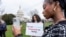 FILE - FILE - Devotees of TikTok, Mona Swain, center, and her sister, Rachel Swain, right, both of Atlanta, pose with a sign at the Capitol in Washington, March 13, 2024. 