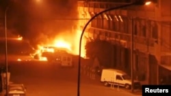 Des véhicules en feu à l'extérieur de l'hôtel Splendid, à Ouagadougou