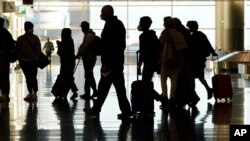 FILE - Air travelers line up to go through a a security checkpoint at Salt Lake City International Airport in Salt Lake City, on Nov. 25, 2020. 