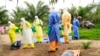 Des agents de la santé, vêtus d’équipement de protection contre le virus Ebola, transportent sur une civière les restes d'un enfant nouveau-né suspecté mort après avoir contracté l’épidémie, à Dubreka, Guinée, le 19 juin 2015
