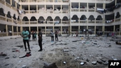 Люди у дворі школи, де живуть переміщені палестинські сім'ї. За повідомленнями Ізраїлю, тут був розташований командний пункт угруповання ХАМАС. Фото: Omar AL-QATTAA/AFP