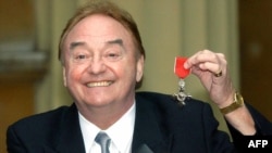 FILE - In this photo taken Dec. 12, 2003, sixties singing sensation Gerry Marsden poses with his MBE for services to Liverpudlian Charities at Buckingham Palace in London